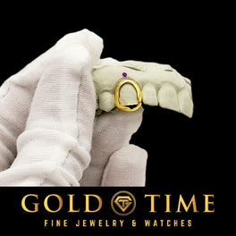 Gloved hand holding a mold with a yellow gold open face single tooth cap, Gold Time logo