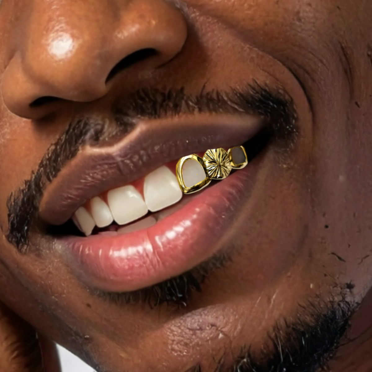 A close-up of a man's mouth wearing a gold tooth grill on his upper teeth.