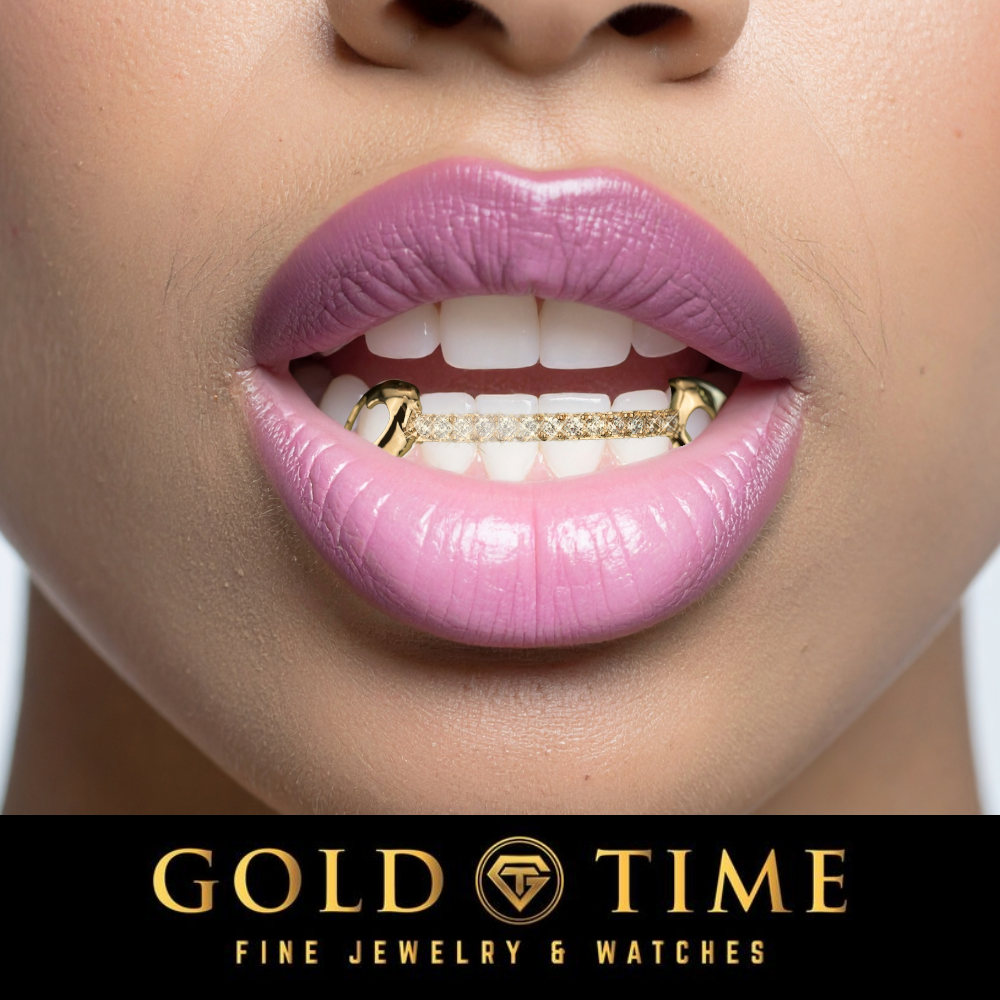 Close-up of a person's mouth wearing a gold tooth grill with a row of small clear stones, with the brand text 'GOLD TIME FINE JEWELRY & WATCHES' on a black banner at the bottom.