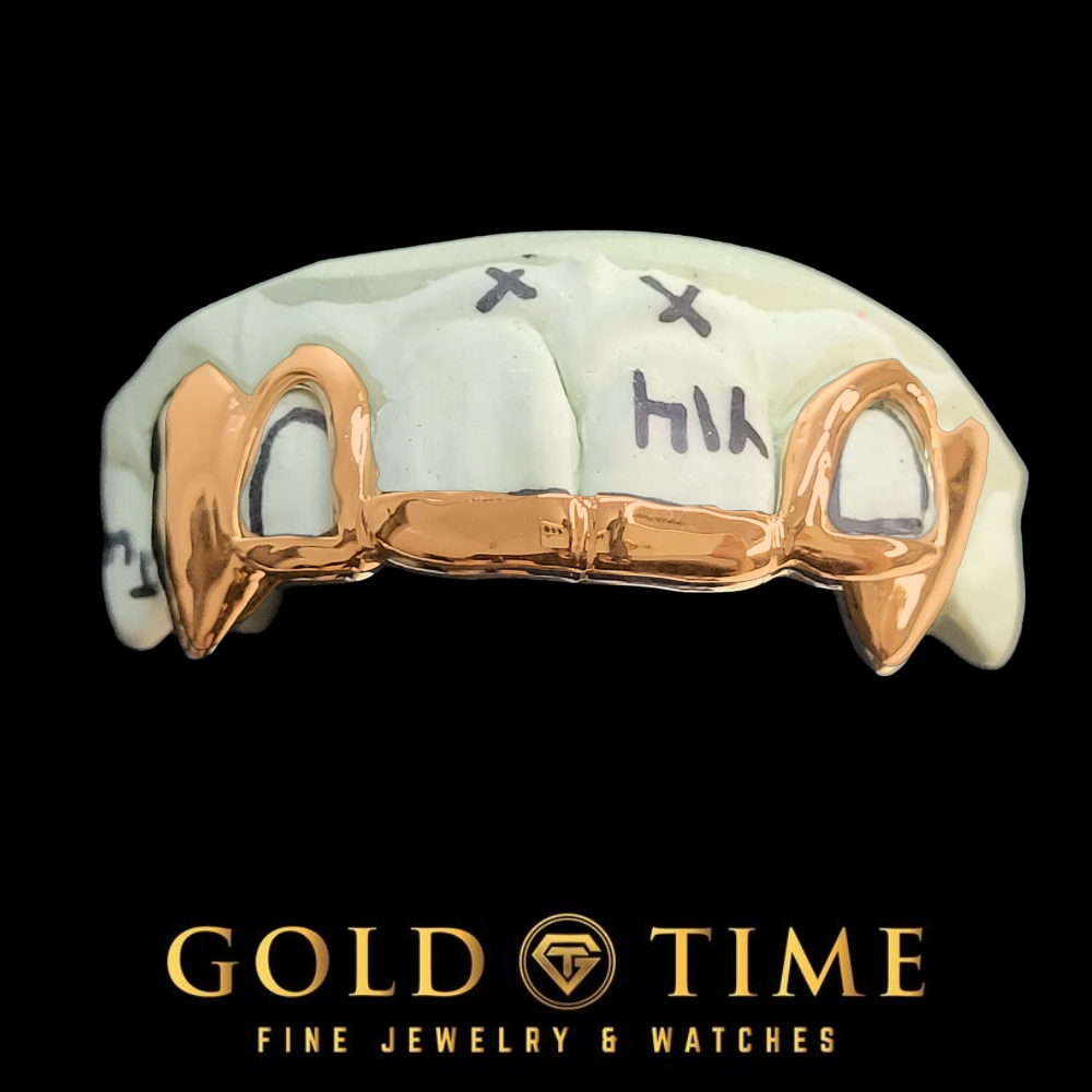 A rose gold open face fang grillz, with black hand-written markings on the front. The image is set against a solid black background with the brand logo 'GOLD TIME FINE JEWELRY & WATCHES' at the bottom.