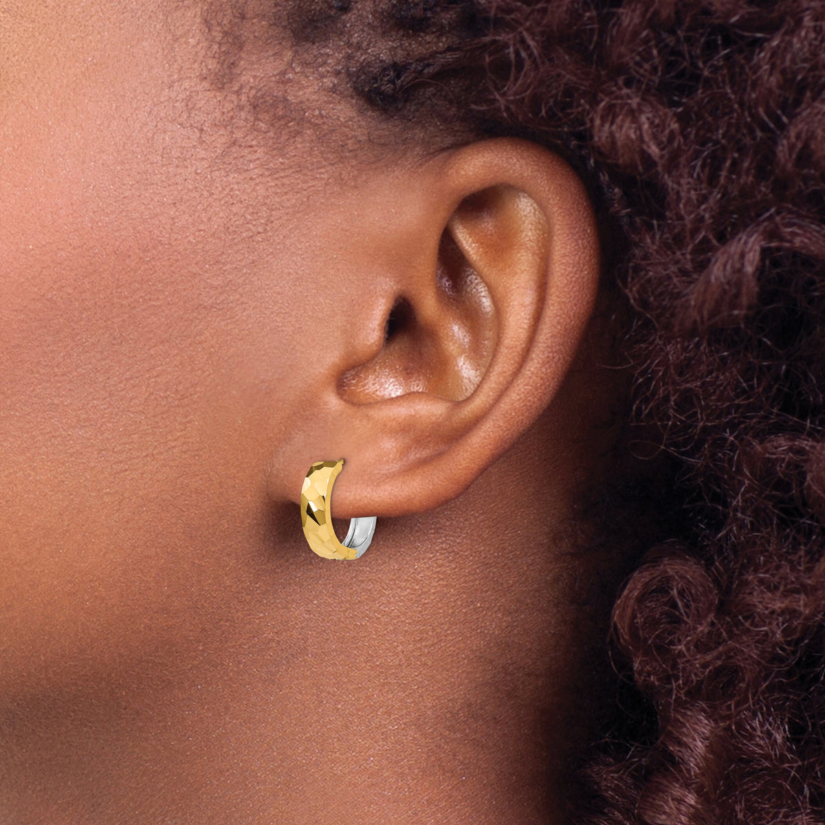 14K Two-Tone Gold Textured Hinged Huggie Earrings in yellow and white gold, worn on the ear