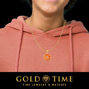 A gold chain necklace with a circular basketball pendant worn by a model in a dusty rose hoodie, with a black banner at the bottom reading 'GOLD TIME FINE JEWELRY & WATCHES'.