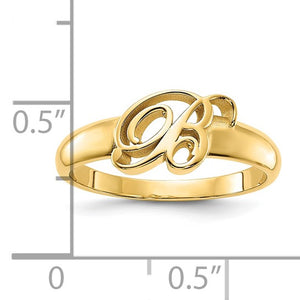 Yellow gold cursive B initial ring beside a half inch ruler for scale