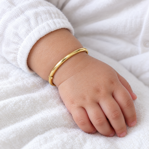 14K yellow gold hinged baby bangle worn on a baby's wrist, lifestyle photo, Gold Time