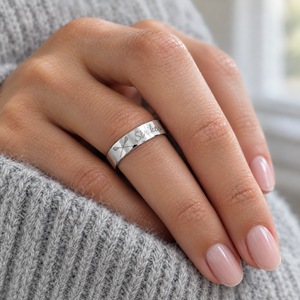 White gold flat band engraved Striker with crossed lacrosse sticks, worn on a woman's finger, lifestyle photo, Gold Time
