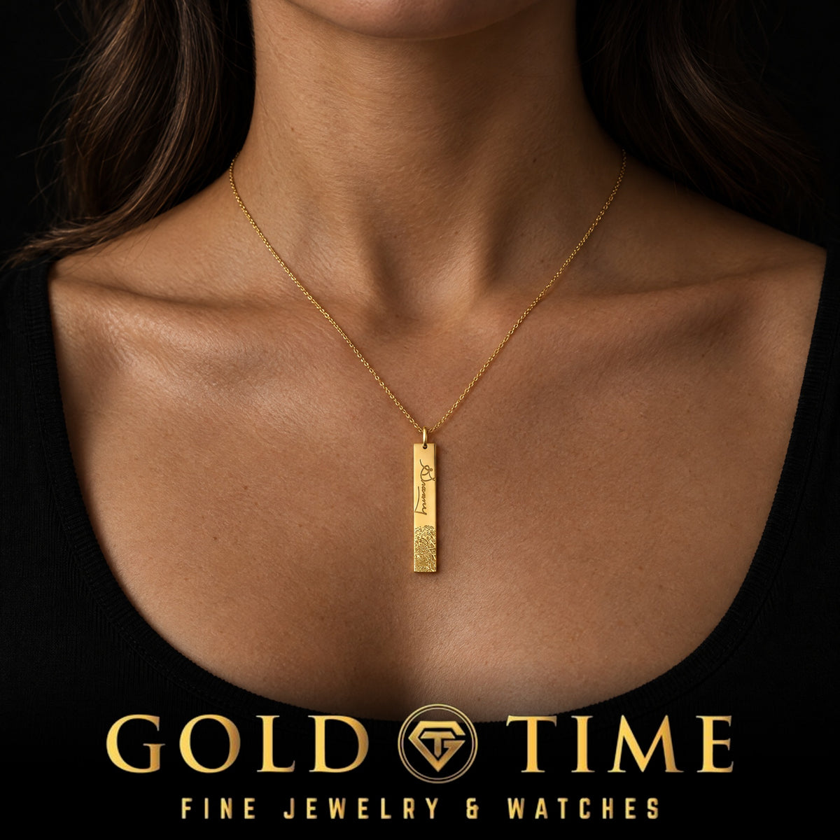Woman wearing a yellow gold fingerprint and signature bar pendant on a fine cable chain, Gold Time