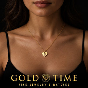 Woman wearing a yellow gold heart charm with a cut-out letter B on a dainty chain, Gold Time
