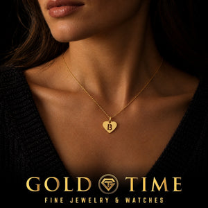 Yellow gold cut-out initial heart charm worn at the base of the neck with a dark sweater, Gold Time