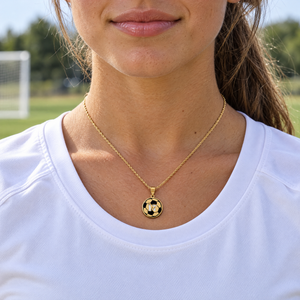 Yellow gold soccer ball pendant with black enamel and cutout 17, worn by a young woman athlete, lifestyle photo, Gold Time