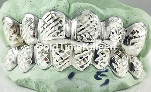 Silver box trillion diamond cut grillz resting on a green dental impression