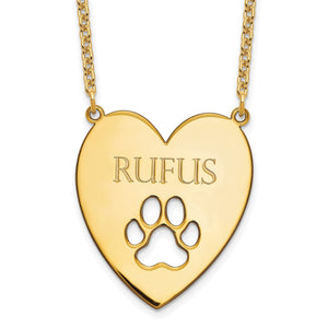 Close-up of gold heart pendant engraved with a dog's name above a paw print cutout