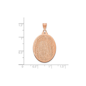 Rose gold fingerprint pendant against an inch scale for size reference
