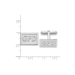 Silver rectangle monogram cuff links beside a ruler, measuring about three quarters of an inch