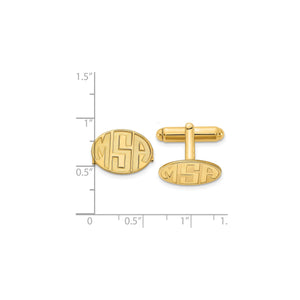 Gold oval monogram cuff links beside a ruler, measuring about three quarters of an inch