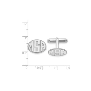 Sterling silver monogram cuff links next to a ruler for scale