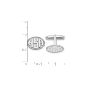 White rope border monogram cuff links against an inch ruler