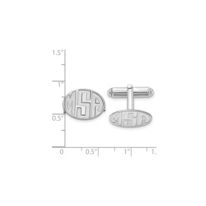 Silver oval monogram cuff links beside a ruler for scale