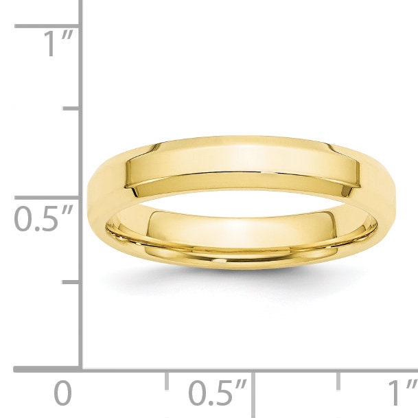 Yellow gold band next to an inch ruler for scale