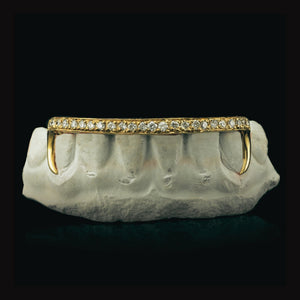 Yellow gold open face hooks grillz with a moissanite bar across six teeth, on a dental mold