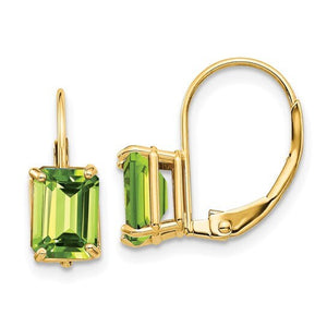 Close-up of 14k yellow gold leverback earrings set with green peridot emerald-cut stones in four-prong settings