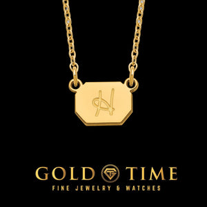 Yellow gold octagonal initial charm necklace with an engraved script letter on a cable chain