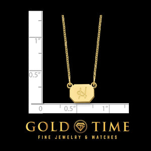 Yellow gold initial necklace measured against a ruler, charm just under half an inch tall