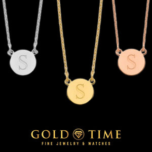 Dainty initial circle necklaces with a block letter S in silver, yellow gold and rose gold, on a black background with Gold Time branding