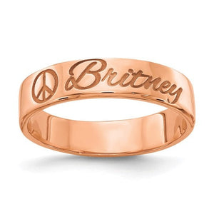 Rose gold flat band engraved with a name in script beside a small symbol