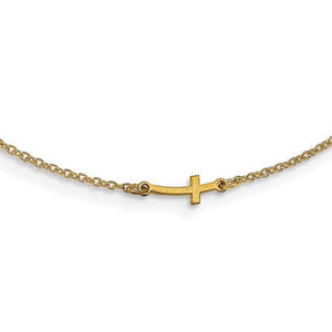 Close up of a small sideways gold cross set on a dainty cable chain