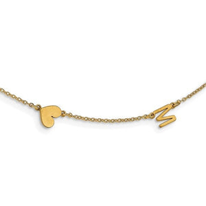 Close up of a gold initial necklace with a small polished heart and letter M set on the chain