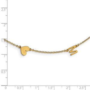 Gold heart and letter M initial necklace next to a ruler showing the small charm size