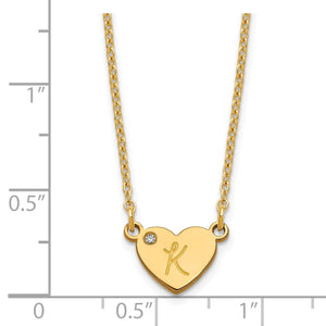 Gold heart initial necklace beside a ruler showing the heart is about half an inch wide