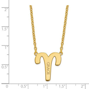 Yellow gold Aries zodiac pendant beside a ruler showing it measures about three quarters of an inch