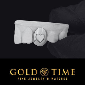 White gold single tooth cap with a heart shape cut out on a dental mold