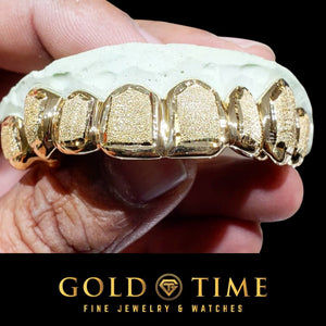 White gold 6 piece diamond dust grillz fitted to a dental mold on a black background