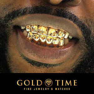 Man smiling while wearing yellow gold solid perm cut grillz on his top and bottom teeth