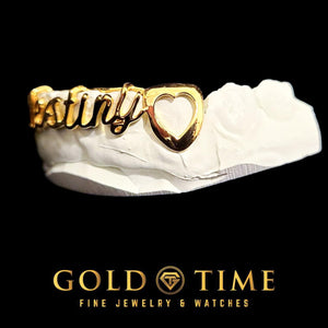 Side view of a gold cursive name grill showing an open heart cut-out canine cap at the end of the name
