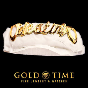 Angled view of a 6 piece gold cursive name grill reading Destiny with open heart canines on a white mold