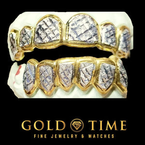 Full top and bottom 12 piece two-tone grill with yellow gold box frames around trillion cut diamond dust faces