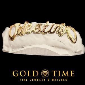 Custom 6 piece gold name grillz with a cursive nameplate reading Destiny across the front teeth and open cut-out canines, on a dental mold