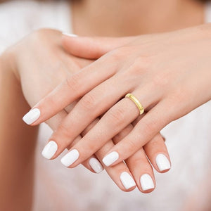 Hand wearing a yellow gold wedding band