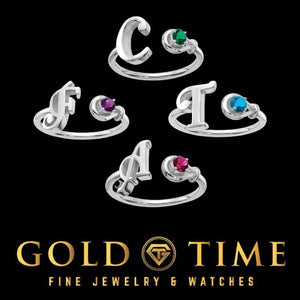 Five sterling silver initial birthstone rings showing different letters and stone colors