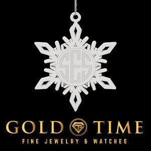 White pewter snowflake ornament with an engraved monogram in the center, on a black Gold Time card
