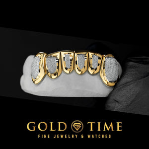 6 piece top grill with white diamond dust faces inside yellow gold box frames on a dental mold
