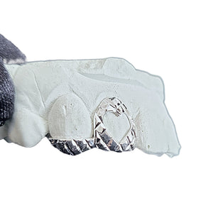 Custom silver heart cut-out trillion double cap grillz on a mold