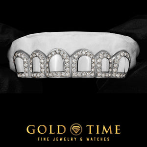 White gold six tooth grillz with a hand set moissanite border framing each solid cap, held in a gloved hand