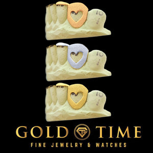 Heart cut out canine grillz shown in yellow, white and rose gold on dental models