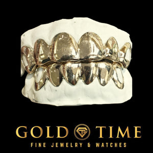 Yellow gold 12 piece grillz set with open face canines fitted to top and bottom dental molds