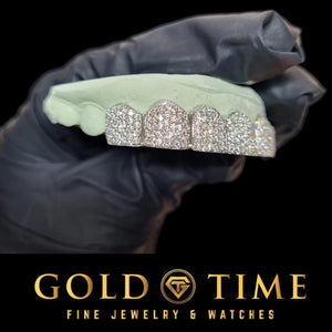 Side view of an 8 piece honeycomb moissanite grill held in a black gloved hand, showing the perm cut separations