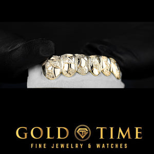 Angled view of the six tooth nugget and diamond dust grillz showing the faceted surface